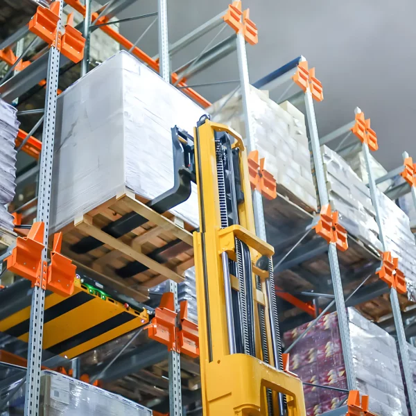 produto sendo colocado por empilhadeira em estrutura de carro satelite